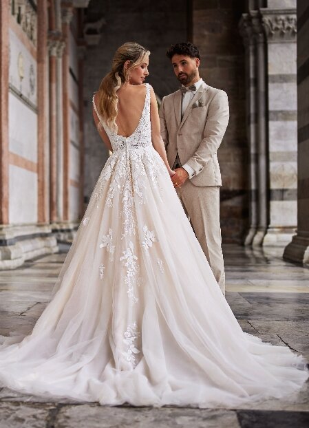 Tres Chic TC25226 trouwjurk, een klassieke en verfijnde ontwerp met een romantische uitstraling. De jurk heeft een vloeiende rok en gedetailleerde kanten accenten, perfect voor een elegant huwelijk.